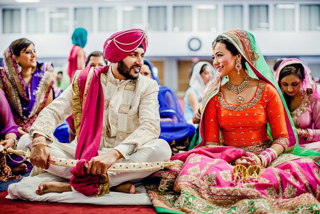Indian bride and groom talking smiling during Sikh wedding