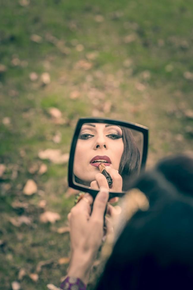 bride putting on lipstick in mirror